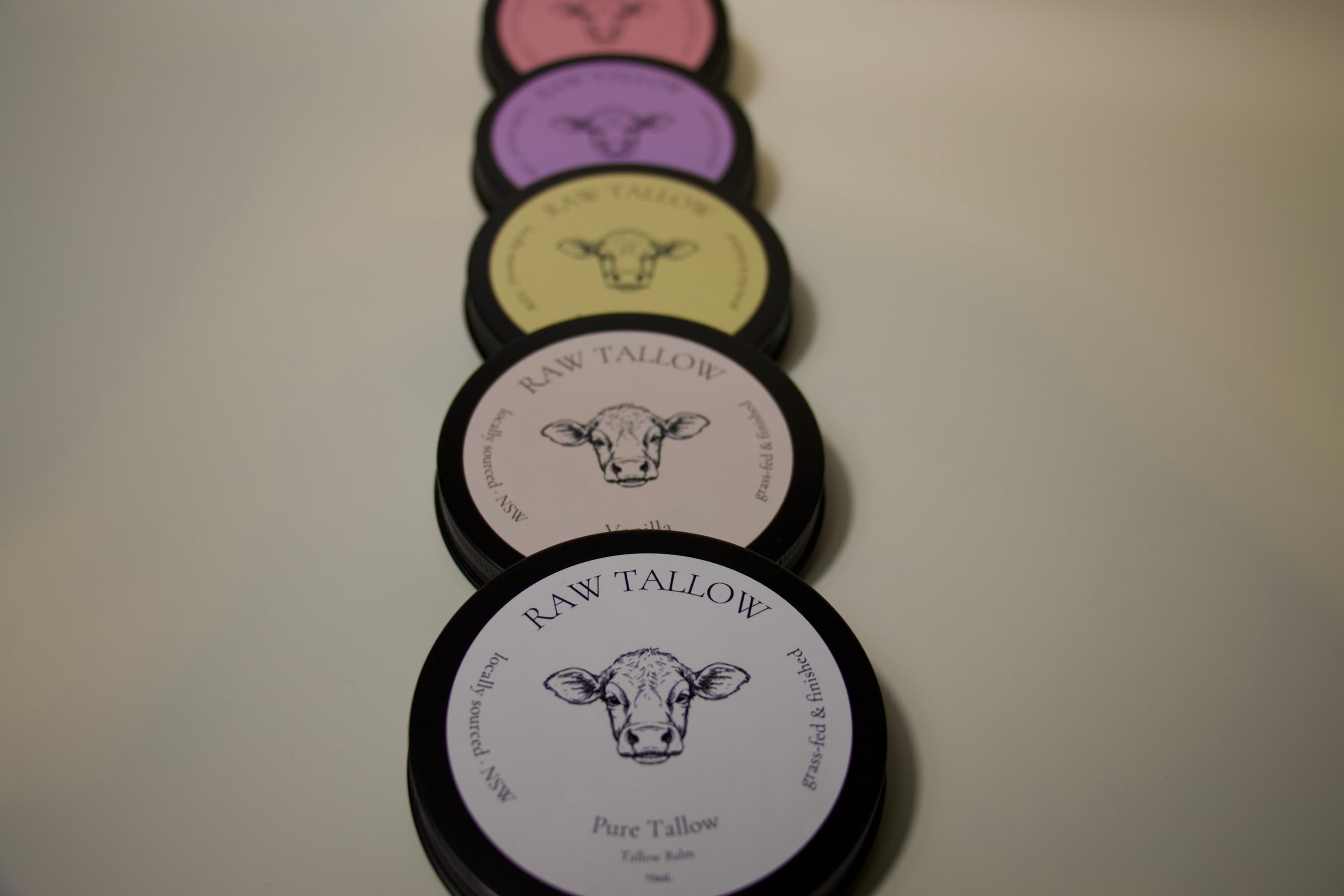 The Raw Tallow collection — five balms on a warm studio backdrop