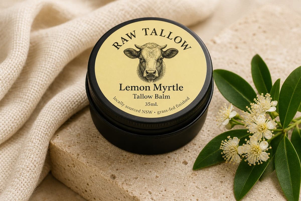 Black amber jar of Raw Tallow Lemon Myrtle Tallow Balm with butter-yellow circular label and native myrtle leaves